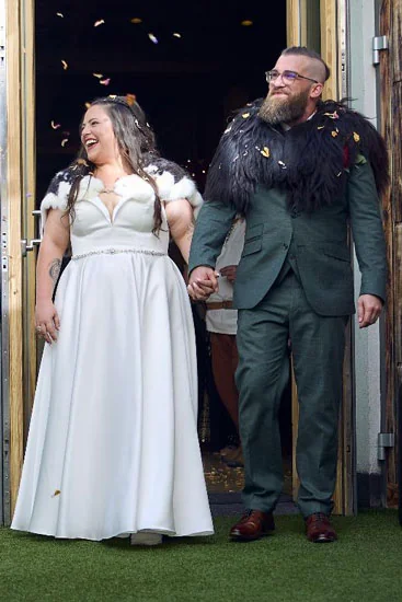 Glückliches Brautpaar verlässt nach der Hochzeit lachend die Kirche, Konfetti fliegt in der Luft