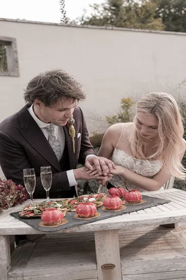 Braut und Bräutigam schneiden gemeinsam eine Torte an