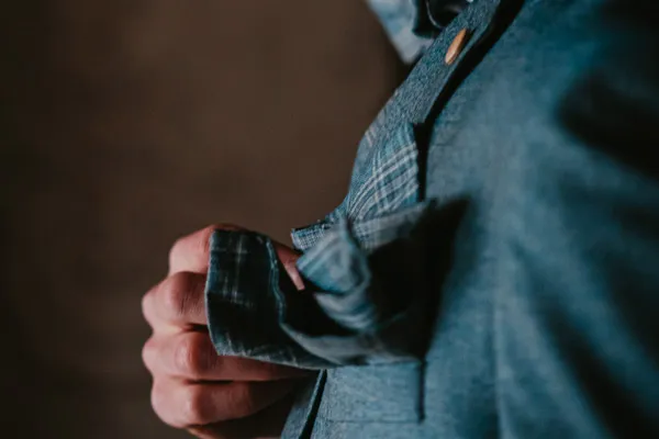 Bräutigam steckt ein stilvolles Einstecktuch in die Anzugtasche