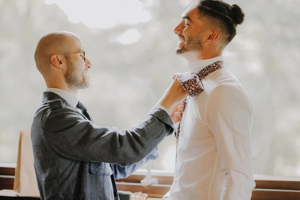 Bräutigam in stilvollem Hochzeitsanzug in der Tenne bei den letzten Vorbereitungen