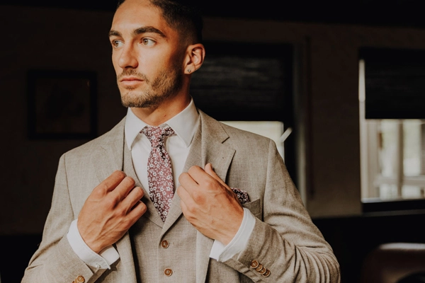 Bräutigam prüft den perfekten Sitz seines stilvollen Hochzeitsanzugs vor der Hochzeit