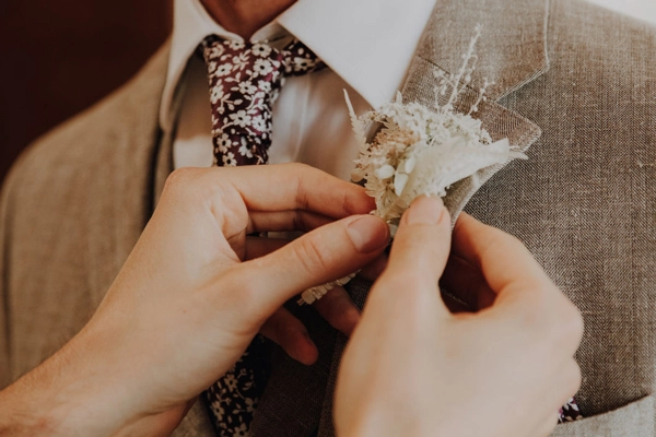 Detailaufnahme von Accessoires des Bräutigams, die das Hochzeitsoutfit vervollständigen