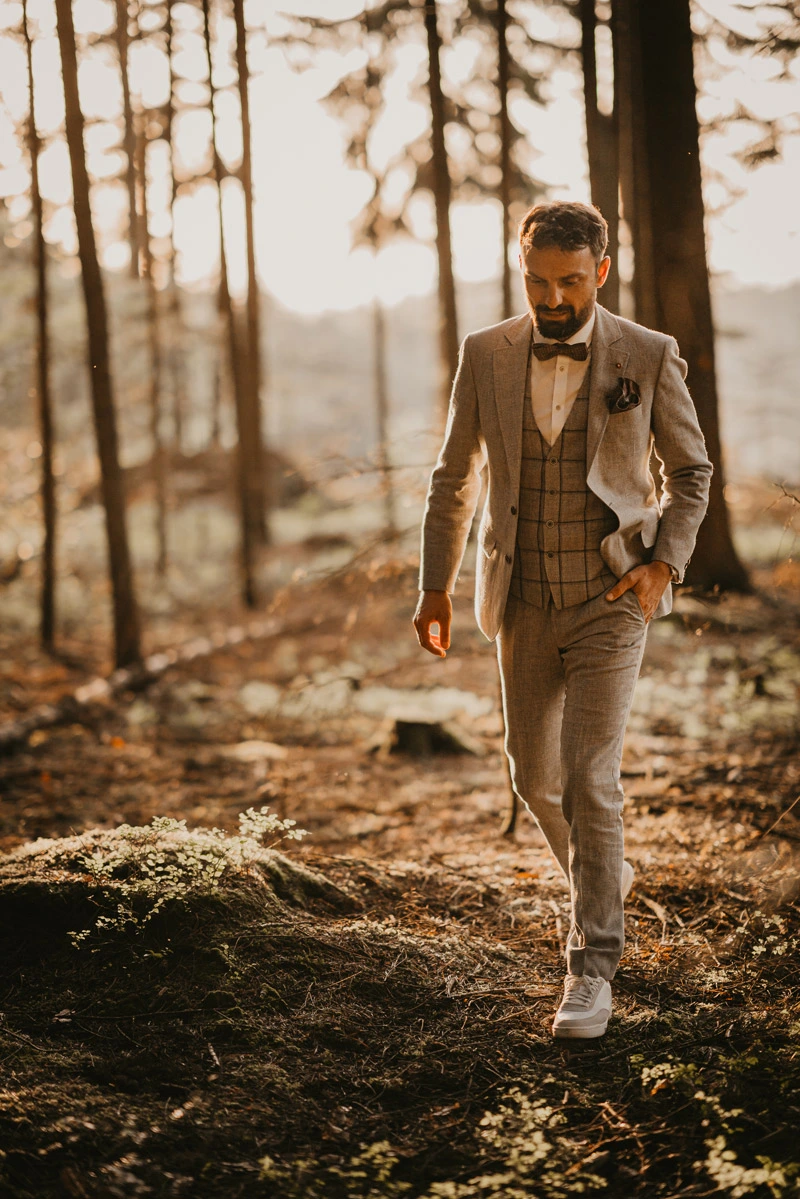 Braut und Bräutigam laufen Hand in Hand den Waldweg entlang