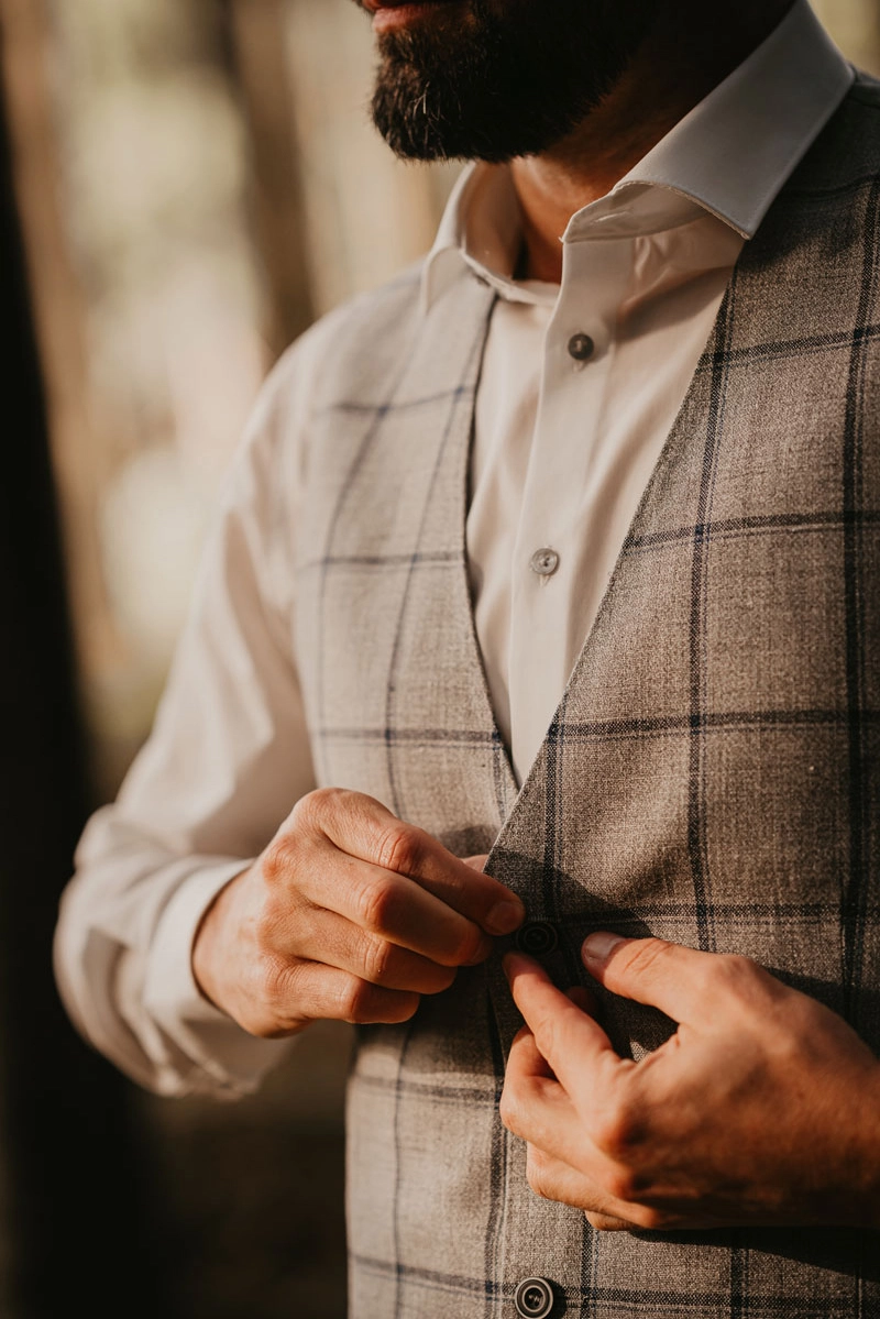 Bräutigam prüft den perfekten Sitz seines Anzugs für die Waldhochzeit