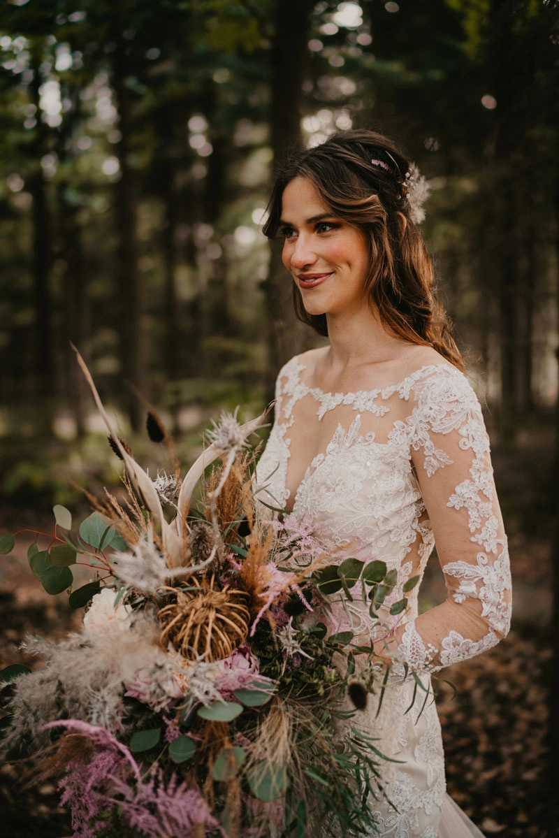 Die wunderschöne Braut in ihrem Hochzeitskleid im Grünen